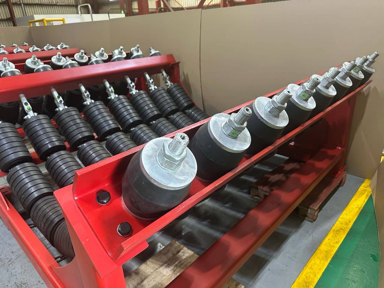 Rubber-cushioned hanger mounts along the side rail of a garland impact bed